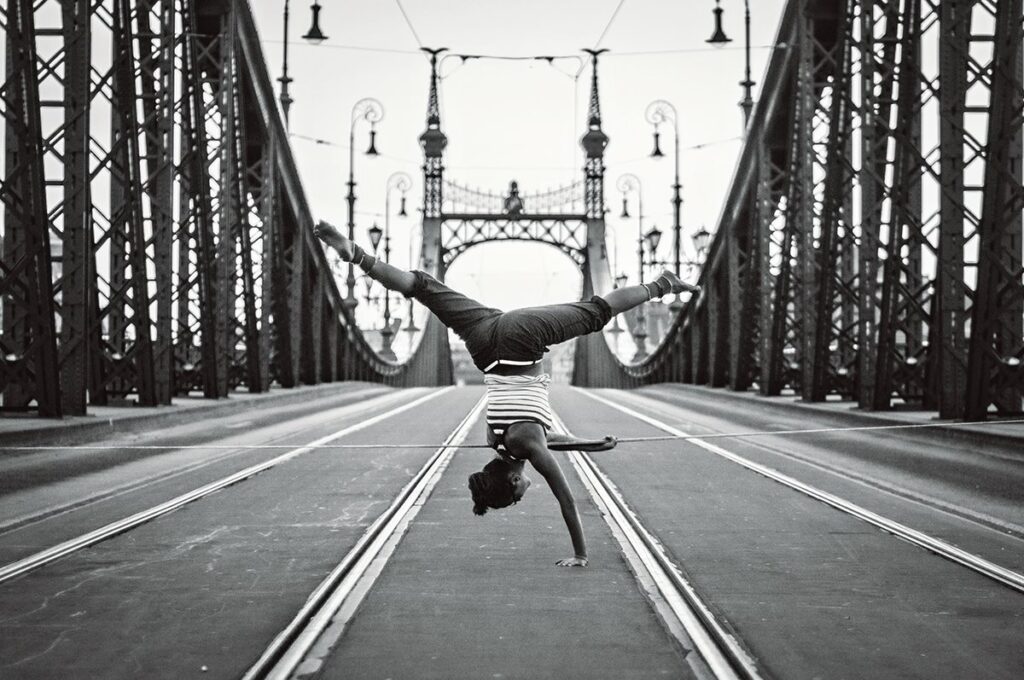 nő vállállásban egy slacklineon a Szabadás hídon